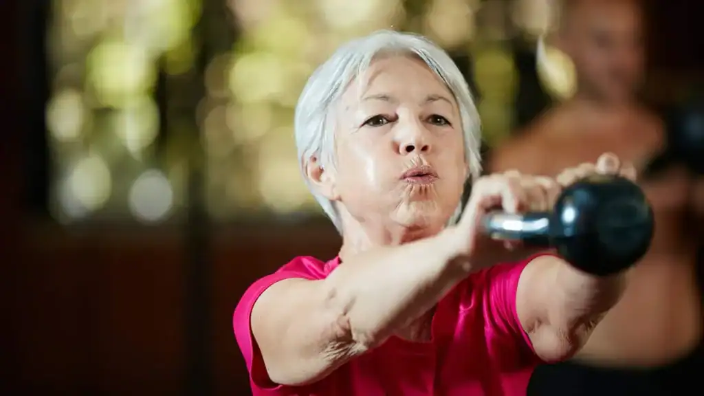 Toning Arms After 60: Empowering Womens Fitness Through Effective Weight Training 1 Older woman doing weight training Willenhall to help her strength and longevity