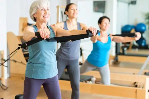 Toning Arms After 60: Empowering Womens Fitness Through Effective Weight Training 2 older woman doing weight training Willenhall and resistance in the gym to tone upper arms