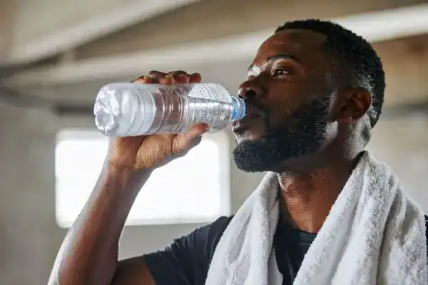 Hydration: The Secret Ingredient for a Toned Stomach and Enhanced Fitness 1 Image of man drinking water to improve hydration Willenhall after work out.